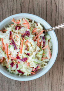 coleslaw in white bowl with spoon